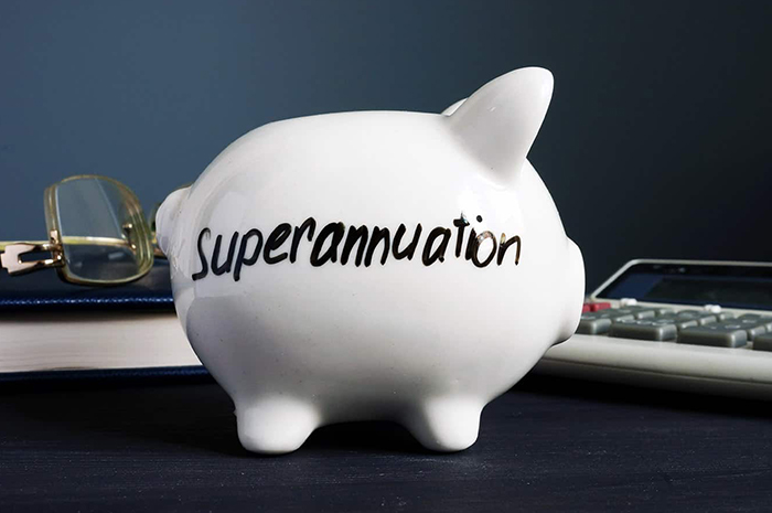 White piggy bank with superannuation writing calculator and glasses either side