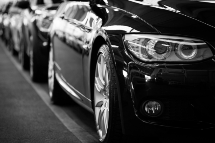 Shiny new black cars all lined up in a row