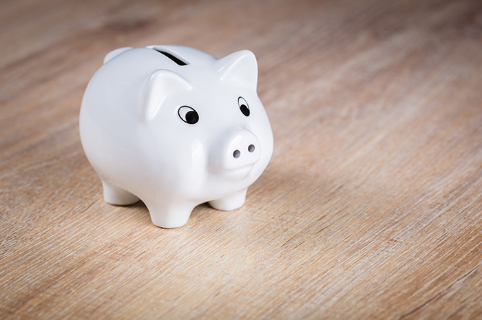 White piggy bank on wooden surface