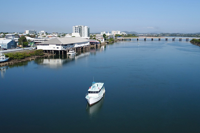 Cruise ship sailing along Pioneer River in Mackay with bridge in background