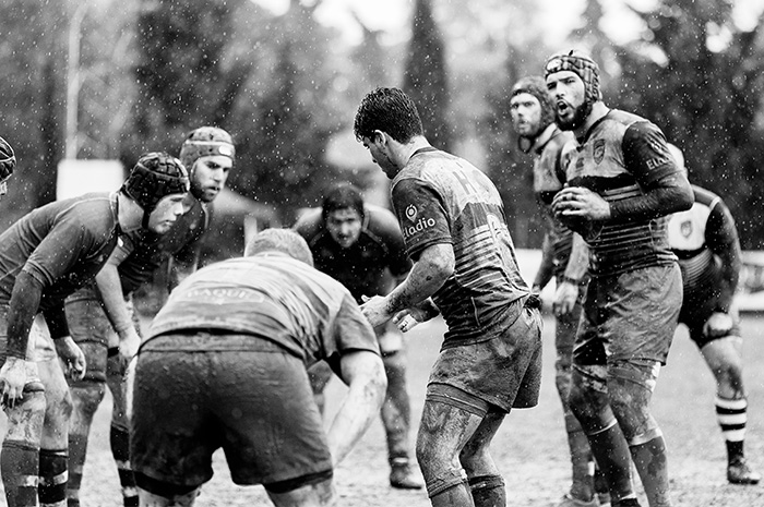 Football team playing on field in rain