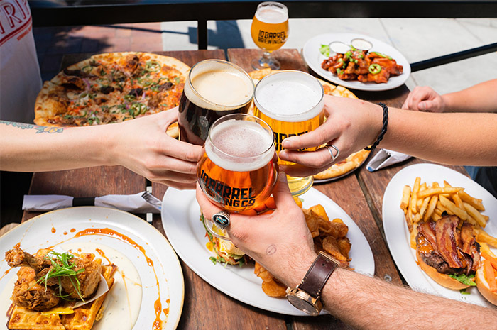 Colleagues cheering beer glasses enjoying a meal together