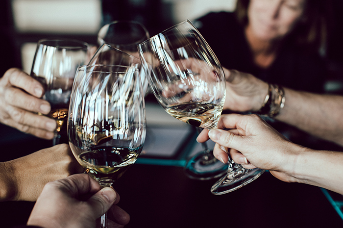 Group of people cheering wine glasses