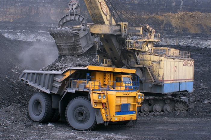 Big mining equipment on site moving coal in back of dump truck