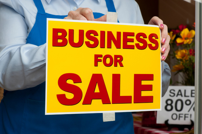 Florist holding up Business For Sale sign