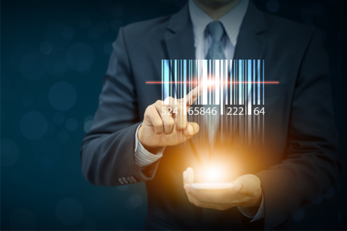 Business man pointing to barcode holding phone with bright light