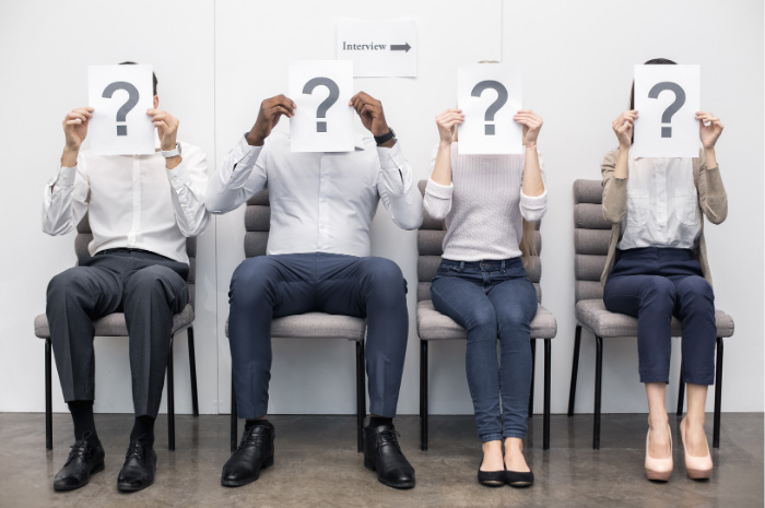 Four interviewees in waiting room with question mark over their faces