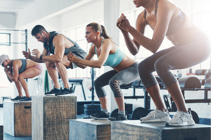 Fitness group doing box jumps