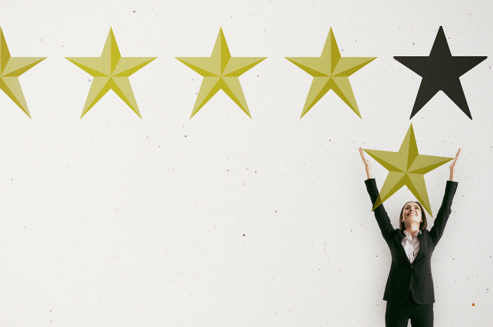 Business woman in suit holding up review stars