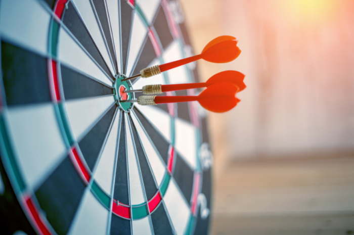 Darts board target with three bullseye darts in the middle