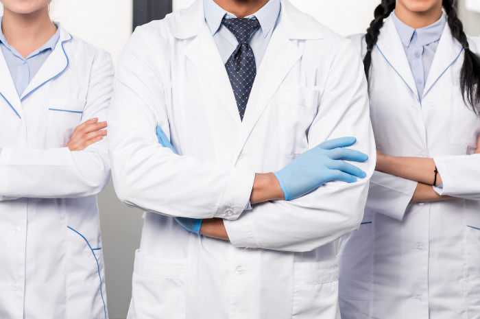 Doctors with arms folded in white protective attire