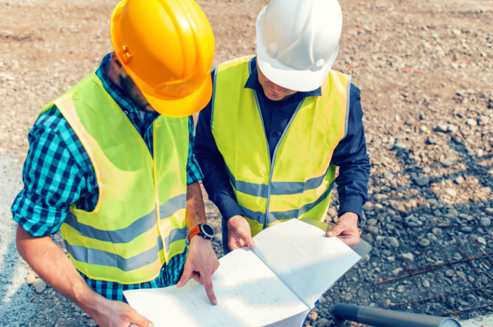 Tradesmen looking over plans on construction site