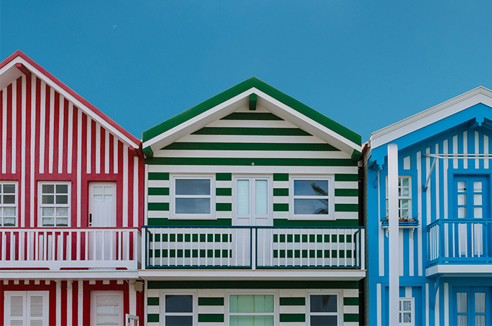Three houses in a row red green and blue stripe paint