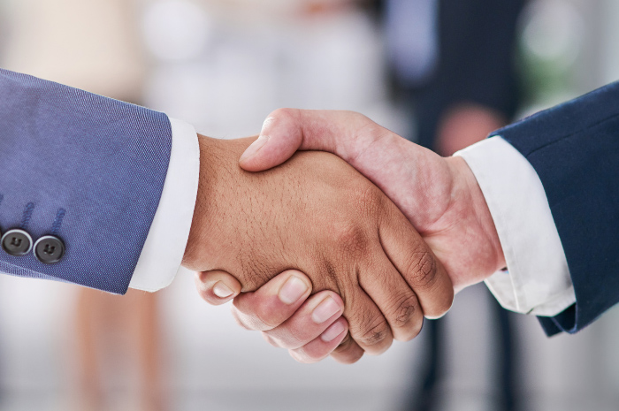 Men in corporate attire shaking hands on business deal