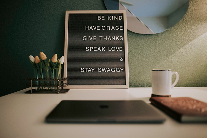 Sign on table with inspiration wording coffee cup book and flowers