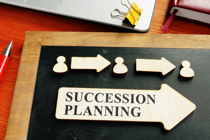 Succession planning concept with wooden figures and arrows.
