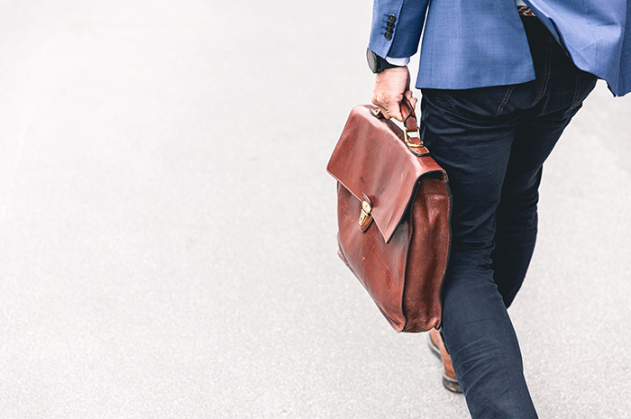 Man walking away with tan brief case