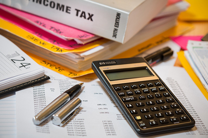 Tax folders diary pen calculator and files on desk