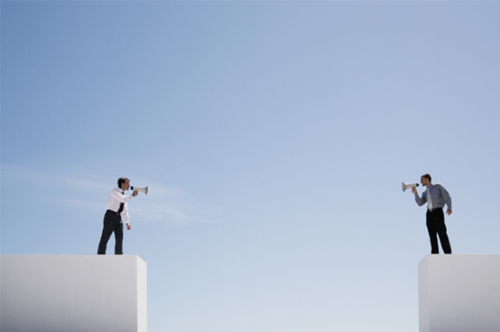 Two men in corporate attire with speaker phones yelling on opposite podiums gap in between