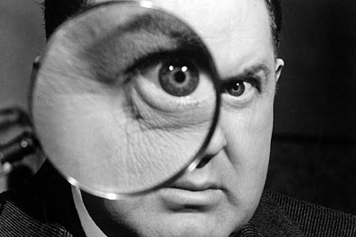 Man looking through magnifying glass