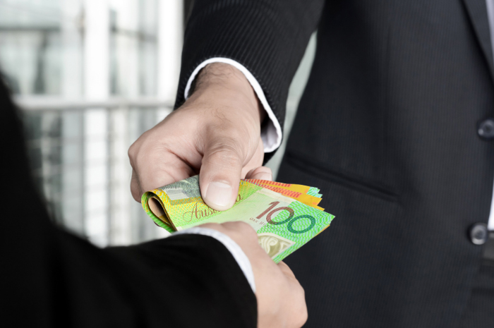 Men in business suits exchanging Australian dollars