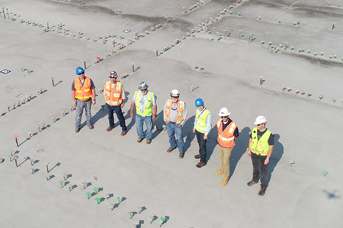 7 work men in high visibility workwear standing on construction site