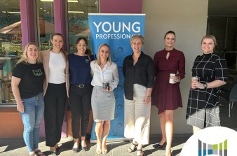 Group of ladies standing in front of a Young Professionals banner