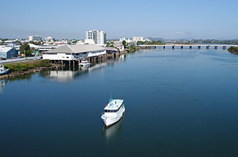Cruise ship sailing along Pioneer River in Mackay with bridge in background