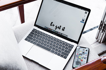 Laptop and phone on chair with wording GO GET IT on laptop screen