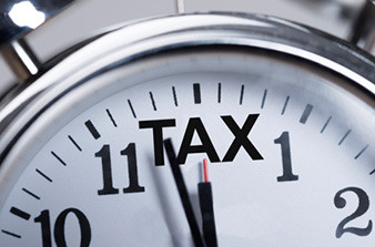 Clock face with word TAX instead of number 12