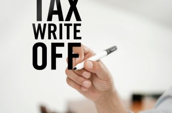 Hand holding marker to write "Tax Write Off"
