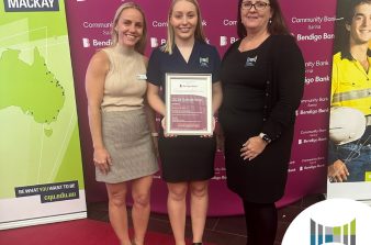 Brooke holding a scholarship certificate from Community Bank Sarina Bendigo Bank for her studies at CQ University