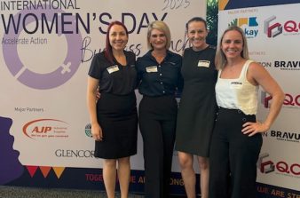 Ladies from DGL Accountants standing in front of International Women's Day poster